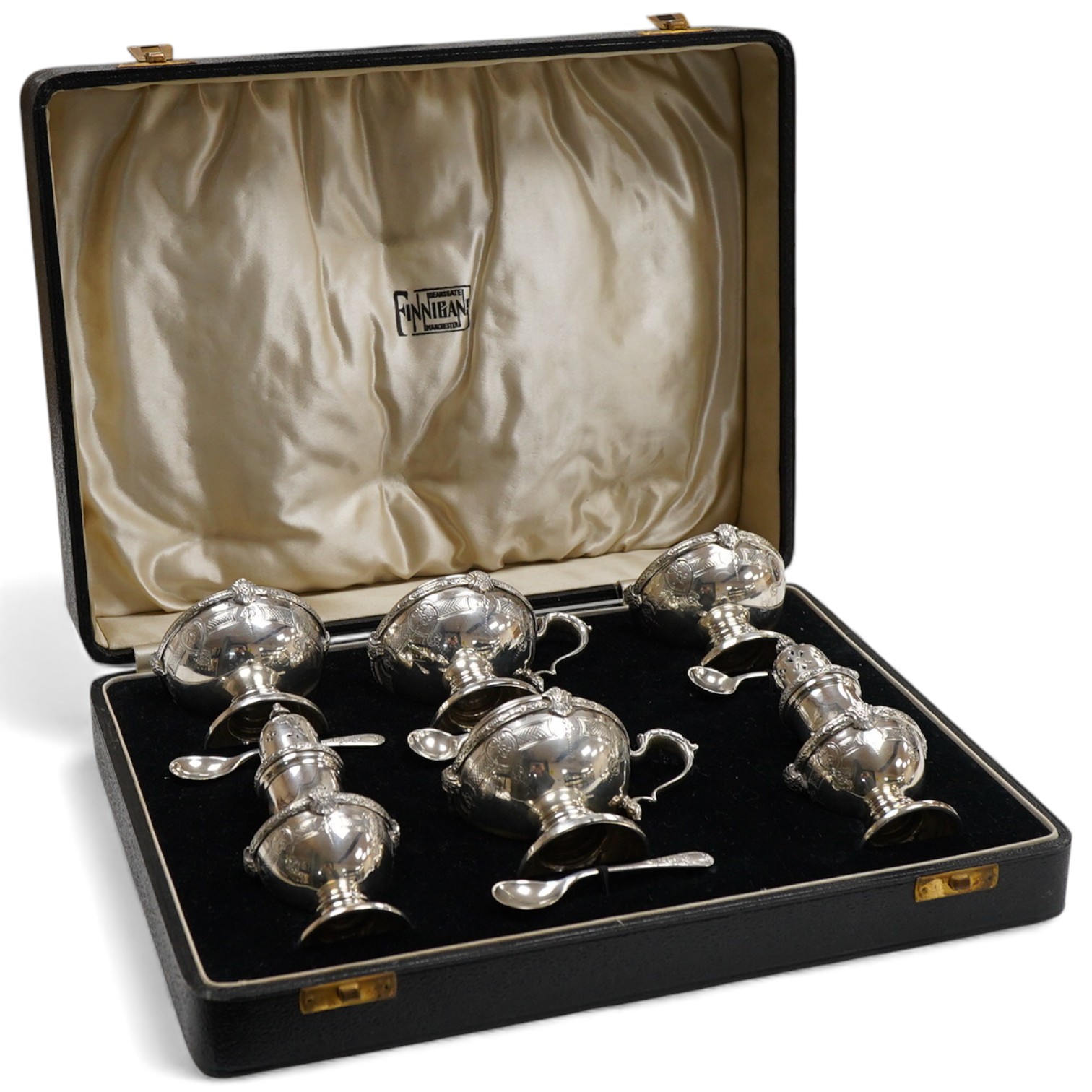 A cased six piece silver condiment set by Finnegans, Ltd, Birmingham, 1940, together with four earlier matched silver condiment spoons by Adie Brothers, 20oz.